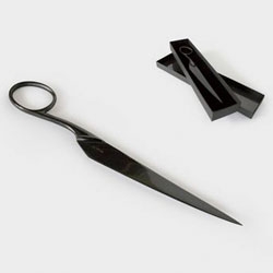 A black-plated steel paper knife shaped like scissors, by Atypyk. 