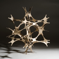 Self-interlocking plywood components form a lattice network, which can be added to indefinitely. Several  formations may be created using a single module type. 250 pieces ltd ed. Venatici can be constructed to make a sculptural table-piece or hanging mobile.