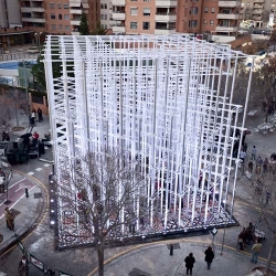 Art collective Pink Intruder has realized a pavilion made with cardboard tubes with a metallic appearance atop a mosaic made of 96,000 wooden pieces in the heart of Valencia. 