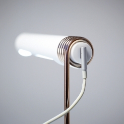 At the end of a chain reaction, an Apple adaptor links power to Castor’s Coil Lamp.