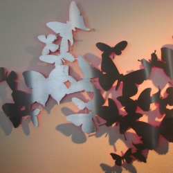 Silver butterflies in stainless steel dance on the wall, creating a dreamy atmosphere with a fluorinated layer on the back