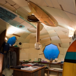 A photo essay on SF artist and surfer Jay Nelson, whose wooden structures include a submarine-shaped surf shop, tree houses, and domed pods on wheels. 