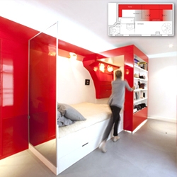 Paul Coudamy's 'Red Nest' in Paris, solves a 23 sq m.  dilemma creating a bookshelf that slides along the wall to reveal or conceal the sleeping area, workspace and dressing room.
