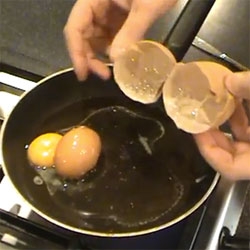 An egg inside an egg? A man cracks up an enormous chicken egg to discover another, complete normal sized egg inside.