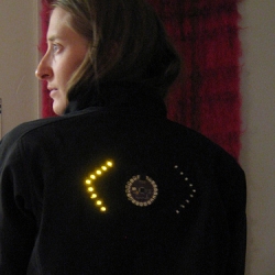 Just a really great idea for bikers, to let the cars behind you know where you are going. Leah Buechley used her LilyPad Arduino to make this soft circuit turn signal bicycle jacket, great for spring.