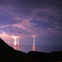  Chris Kotsiopoulos captures an incredible shot of lightning bolts during a lunar eclipse.