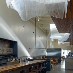 Sky lights at Bar Agricole are fitted with glass sculptural shades which resemble fabric blowing in the wind. The shades are the work of Nikolas Weinstein of Weinstein Studios,