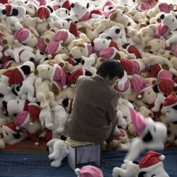 when reading a nytimes article on the suffering economy in china, i spotted this shot of piles of santa snoopys.  one looks like it might be escaping!