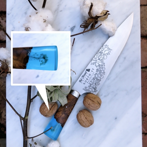 Cut Throat Knives + North St Botanical Chef Knives. A Florist and a Bladesmith collaborate on the design. Each handle boasts a live edge piece of golden mallee burl that is blended with colored transparent resin that contains a solitary flower.