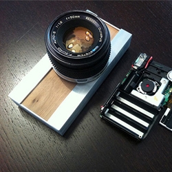 A DIY Digital Lomography Camera with interchangeable lenses, handmade with brushed aluminum and black walnut by blueantstudio.