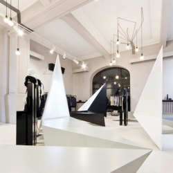 Romanian studio Square One have completed a clothing store, Entrance, in Bucharest with pointy display stands and a network of black electrical cables. 