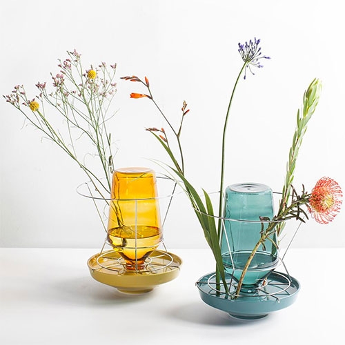 Hidden Vases by Chris Kabel for Valerie Objects. Design is based on how chicken waterers work, and the goal was to make the vase seem invisible, and the flowers appear to grow from the plate.