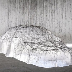Fishing line strung along the ceiling... glue gun drizzled glue drips down... its strands sticking to the plastic sheet over the Mercedes-Benz CLA = a ghostly art piece  by Yasuaki Onishi. Beautiful making of!