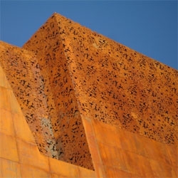 New Caixa building by Herzog & de Meuron in Madrid.  Rusted steel plates make the new building dissapear between the old brick construction.