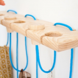 The Hook-It String Project expects you to have a little fun in life. By playing with the wooden knobs, the brightly colored blue ropes raise or lower to change the size of the loops for hanging objects from. 