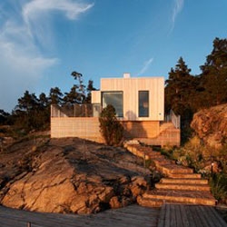 This house by Marge Arkitekter is located in the Swedish archipelago. Dressed in larch panels and sedum moss roof  the house is built to age with the surrounding landscape.