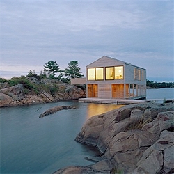 Lake House by MOS Architects. A prefab structure that was towed across Lake Huron, floating on steel pontoons in order to adapt to constant water height changes. The cedar siding integrates the inside of the house with the lake.