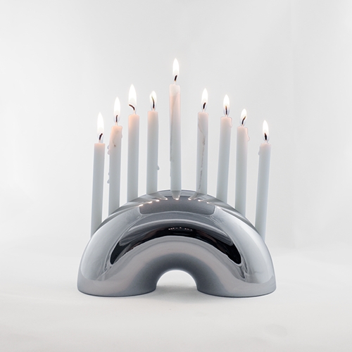 The Nosh Menorah from Modern Mensch is a sculptural menorah inspired by the humble bagel. It is designed to shine in your home with or without candles beyond the standard eight crazy nights.