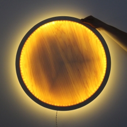 The Eclipse Lamp by Jonathan Odom is a simple wooden circle that hangs on a wall and fades up to a soft glow when turned by hand. See how to make it yourself.