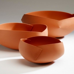 Ann Van Hoey is an industrial designer gone ceramic artist who takes paper to pottery, creating ceramic bowls in the form of origami paper folding. 

