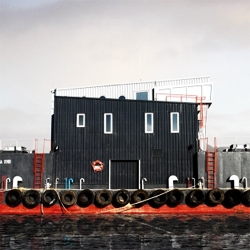 A floating residence for salmon workers in southern Chile. It floats over a big concrete block filled with salmon food.