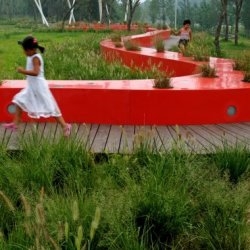 In Qinhuangdao, China the Tanghe River Park features a new installation of a red steel bench that runs for half a kilometre through the park.