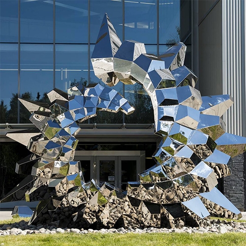 Inflorescence, a polished stainless steel sculpture for the Sciences Building at the University of Alaska Anchorage, uses sensors inside the building to adjust the color of the sculpture based upon level of activity in the building.