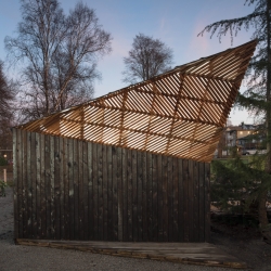 Charred-cedar shed at a community garden in Vancouver, BC, with a unique form that prevents shadows from being cast on surrounding garden plots. By UBC architecture students,