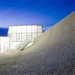 NY-based Steven Holl Architects just completed the new Surf Museum in Biarritz. Set to open in June, the museum is a delicate glowing box resting between stone waves.