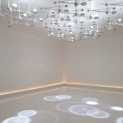 Comprised of 50 ceiling-mounted, LED devices that emanate from a mechanical arm, pushing light through the custom-cut Swarovski crystal lens, Troika's installation at Design Miami is delicate, elegant and exquisite.