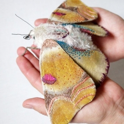 Colorful moths and butterflies by North Carolina based artist Yumi Okita. The pieces are made by hand using fabric, cotton, fake fur, fabric paint, embroidery thread, wire, and feathers.